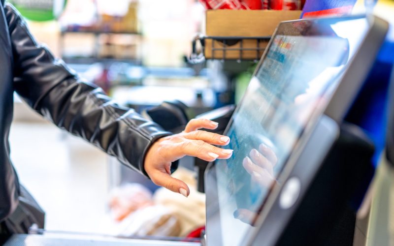 Woman Pressing A Monitor At A Self-Service Checkout In A Supermarket Close-Up
